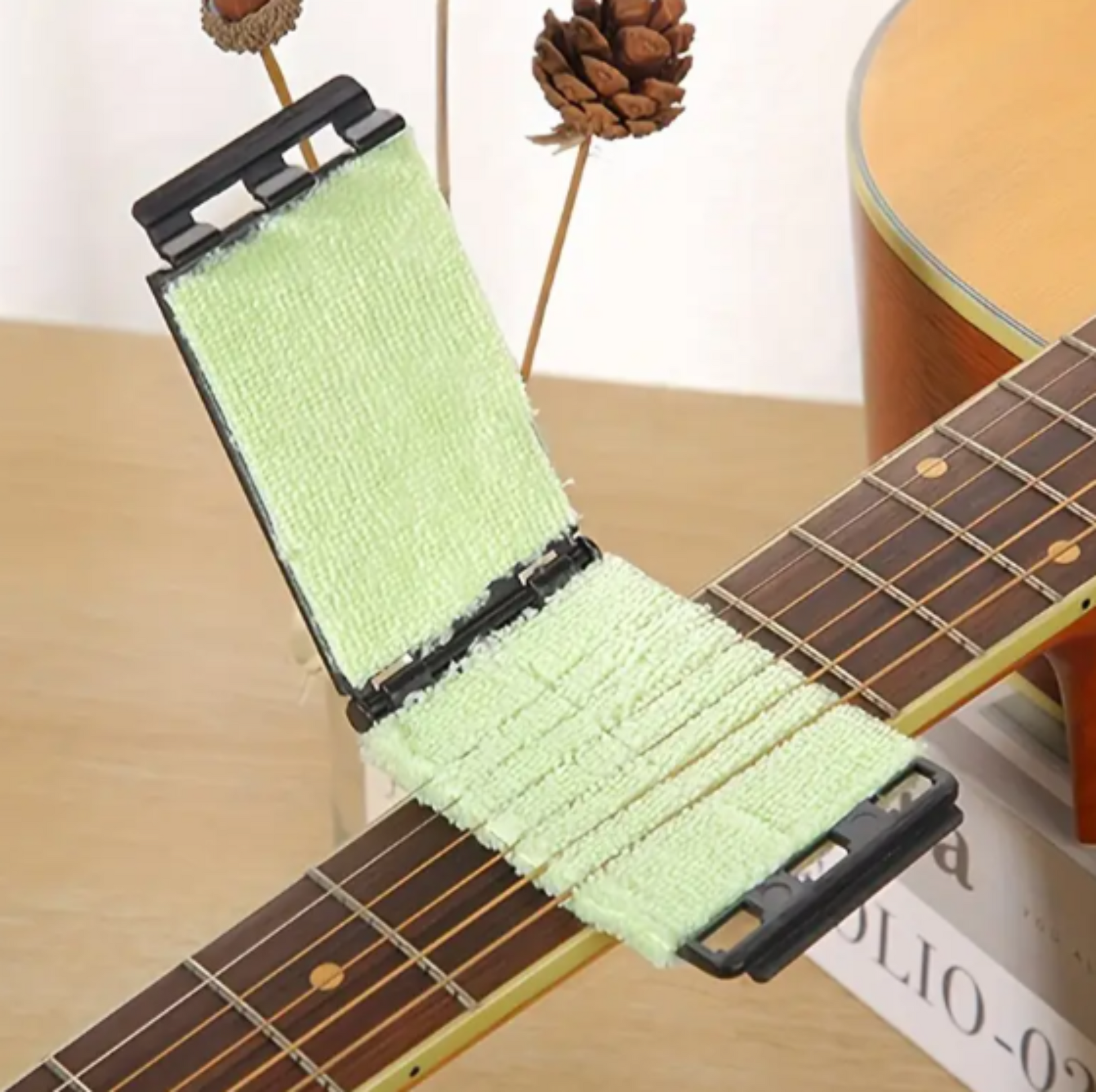 Guitar string cleaner clamped onto strings for secure cleaning